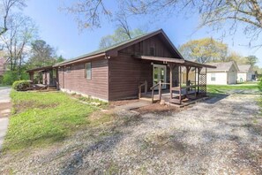 A wooden cabin with a porch and a covered outdoor seating area. - Pawnee Duplex in Chattanooga, Unit 1 (Chattanooga)