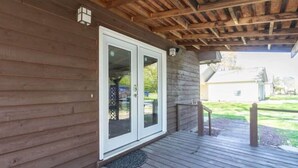 A wooden exterior with a covered porch and a sliding glass door. - Pawnee Duplex in Chattanooga, Unit 1 (Chattanooga)