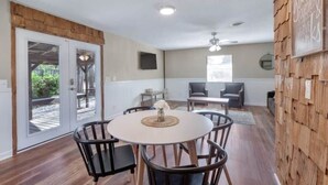 A dining area with a round table, black chairs, and a ceiling fan. - Pawnee Duplex in Chattanooga, Unit 1 (Chattanooga)