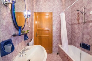 Een bad/douchecombinatie, een bidet, handdoeken