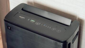 A black printer with a control panel, a power button, and a paper tray.