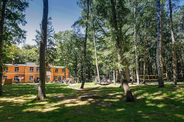 A park with trees, a hammock, and playground equipment.