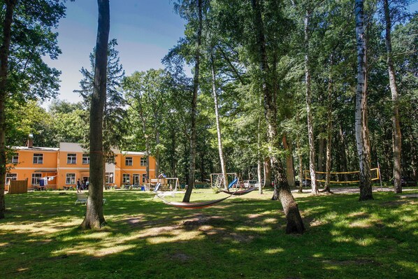 A park with trees, a hammock, and playground equipment.
