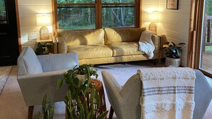 A cozy living room with a sofa, armchairs, and potted plants. - Søsterhus, Three Lakes/Eagle River Lake House (Eagle River)