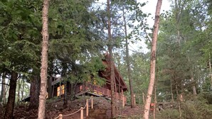 A wooden staircase leading to a cabin surrounded by trees. - Søsterhus, Three Lakes/Eagle River Lake House (Eagle River)
