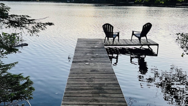 A wooden dock extending into a calm lake with two chairs facing the water, surrounded by trees. - Søsterhus, Three Lakes/Eagle River Lake House (Eagle River)