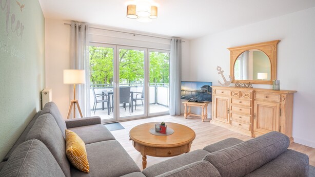 Ein Wohnzimmer mit einer Couch, einem Couchtisch und einem Holzkabinett.