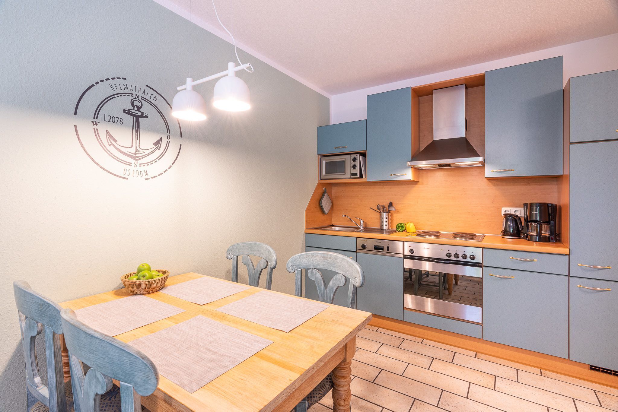 A modern kitchen with a wooden table, chairs, and a microwave.