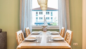 Een eettafel gedekt voor vier personen, met uitzicht op een gebouw.
