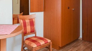 Une pièce comprenant une armoire en bois, une chaise et une table.