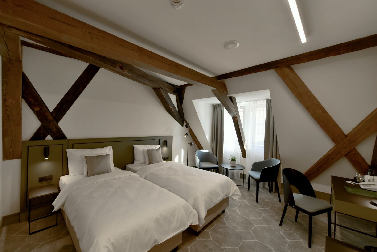 Ein Schlafzimmer mit zwei Betten, einem Schreibtisch und einem Stuhl.