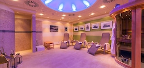 A spa room with a ceiling light, reclining chairs, a massage table, and framed pictures on the wall. - Wohnung 1 und 2 - Strandresidenz-kühlungsborn (Kühlungsborn)