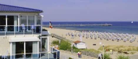 Un bâtiment situé sur la côte, doté d’un balcon donnant sur une plage.