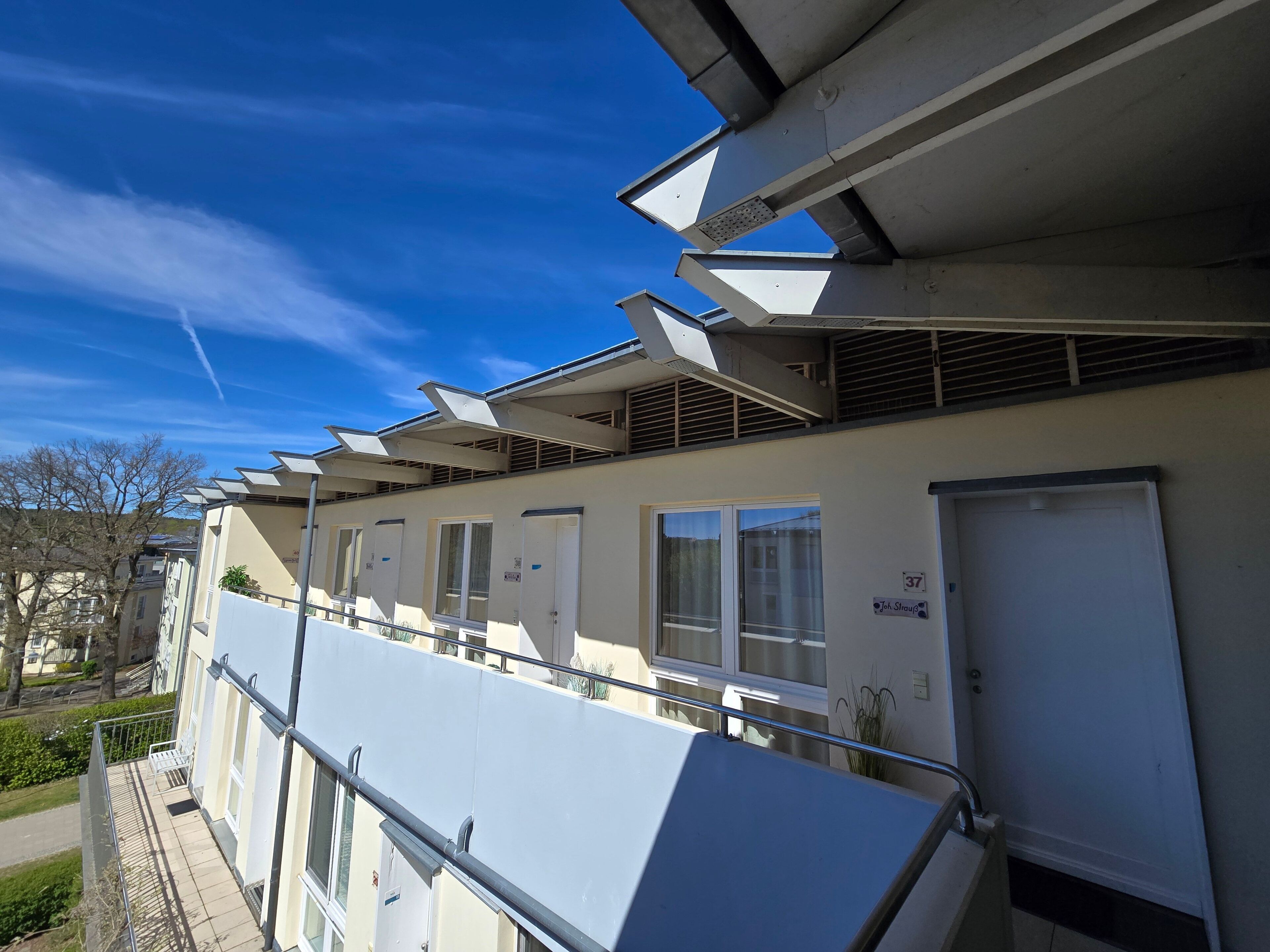 En bygning med flere værelser, en balkon og en dør med teksten 