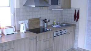 Une cuisine équipée d’un four à micro-ondes, d’un grille-pain, d’une bouilloire et d’un lave-vaisselle.
