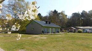 Una casa a un piano con tetto spiovente, un piccolo portico e un garage.