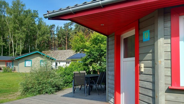 Una cabaña de madera con techo rojo y un cartel con el número 17.