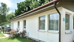 A single-story building with a flat roof, large windows, and a visible number '27' on the wall. - Ferienwohnung 27, Deutschland (Trassenheide)