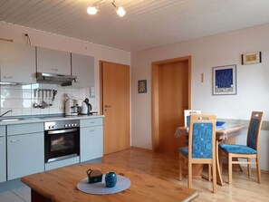 Kjøleskap, mikrobølgeovn, ovn og høy barnestol