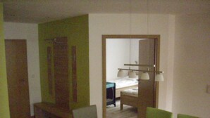 A hotel room with a bed, bedside table, lamp, and a view of a bathroom. - Vacation apartment (wheelchair accessible) 41 - Käuzchenkuhle (Trassenheide)