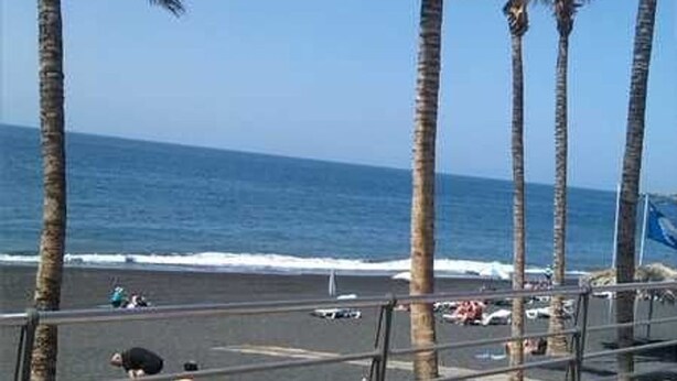 A beach with palm trees and a clear view of the ocean. - Apartment Sol y Playa (Puerto de Naos)