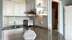 A kitchen with white cabinets, a granite countertop, a toaster, and a colander. - Apartment Sol y Playa (Puerto de Naos)