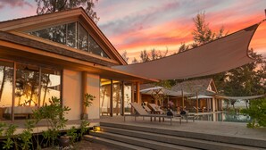A modern house with a large glass window, a pool, and outdoor seating. - The Pines (Takua Thung)