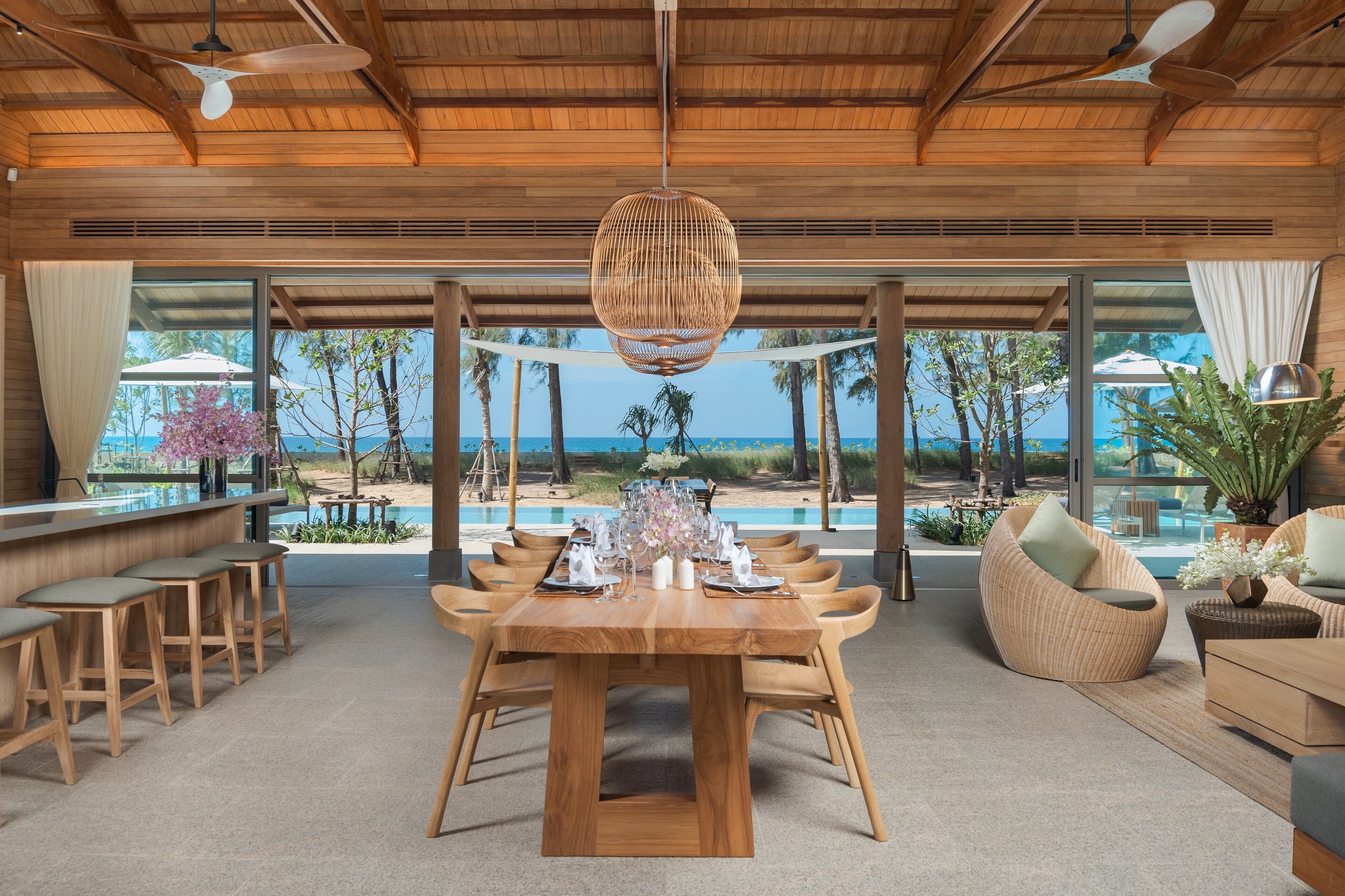 Un comedor espacioso con una mesa de madera dispuesta para seis personas, rodeada de sillas de madera.