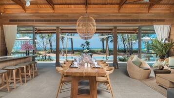 Un comedor espacioso con una mesa de madera dispuesta para seis personas, rodeada de sillas de madera.