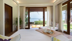 A bedroom with a large bed, a breakfast tray, and a view of the sea. - Ban Suriya (Koh Samui)