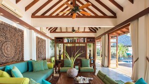 A spacious living area with a wooden ceiling, a central coffee table, and a seating arrangement including sofas and chairs. - Villa Waimarie (Koh Samui)
