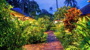 A pathway leading to a building surrounded by lush greenery and palm trees. - Villa Waimarie (Koh Samui)