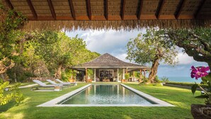 A poolside area with lounge chairs, a pool, and a covered seating area overlooking the ocean. - Cape Laem Sor Estate (Koh Samui)