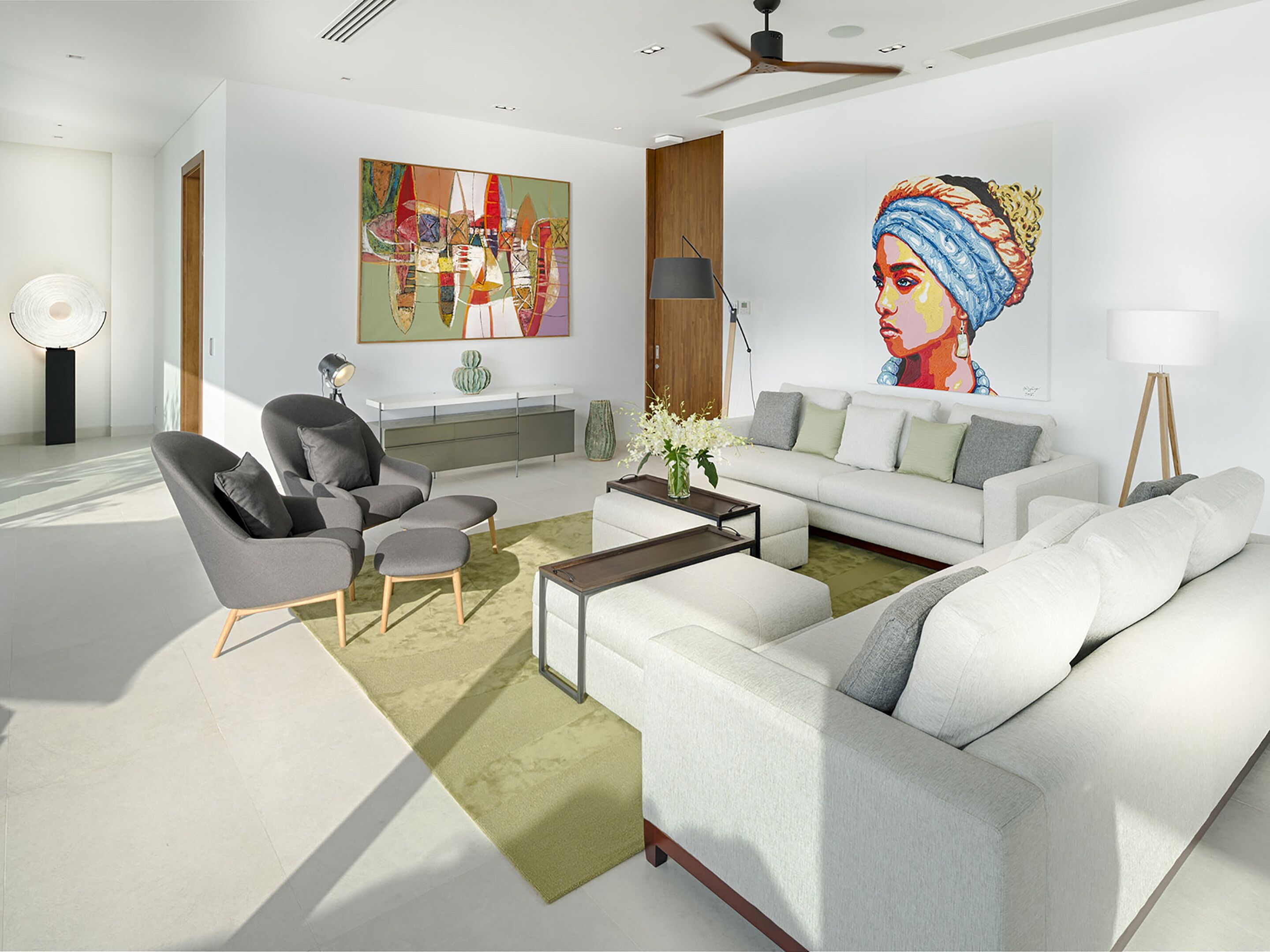 A modern living room with a sofa, armchairs, a coffee table, and a painting on the wall.
