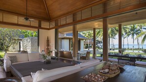 A spacious outdoor seating area with a view of the ocean, featuring a sofa, dining table, and a variety of seating options. - Jivana Beach Villas (Takua Thung)
