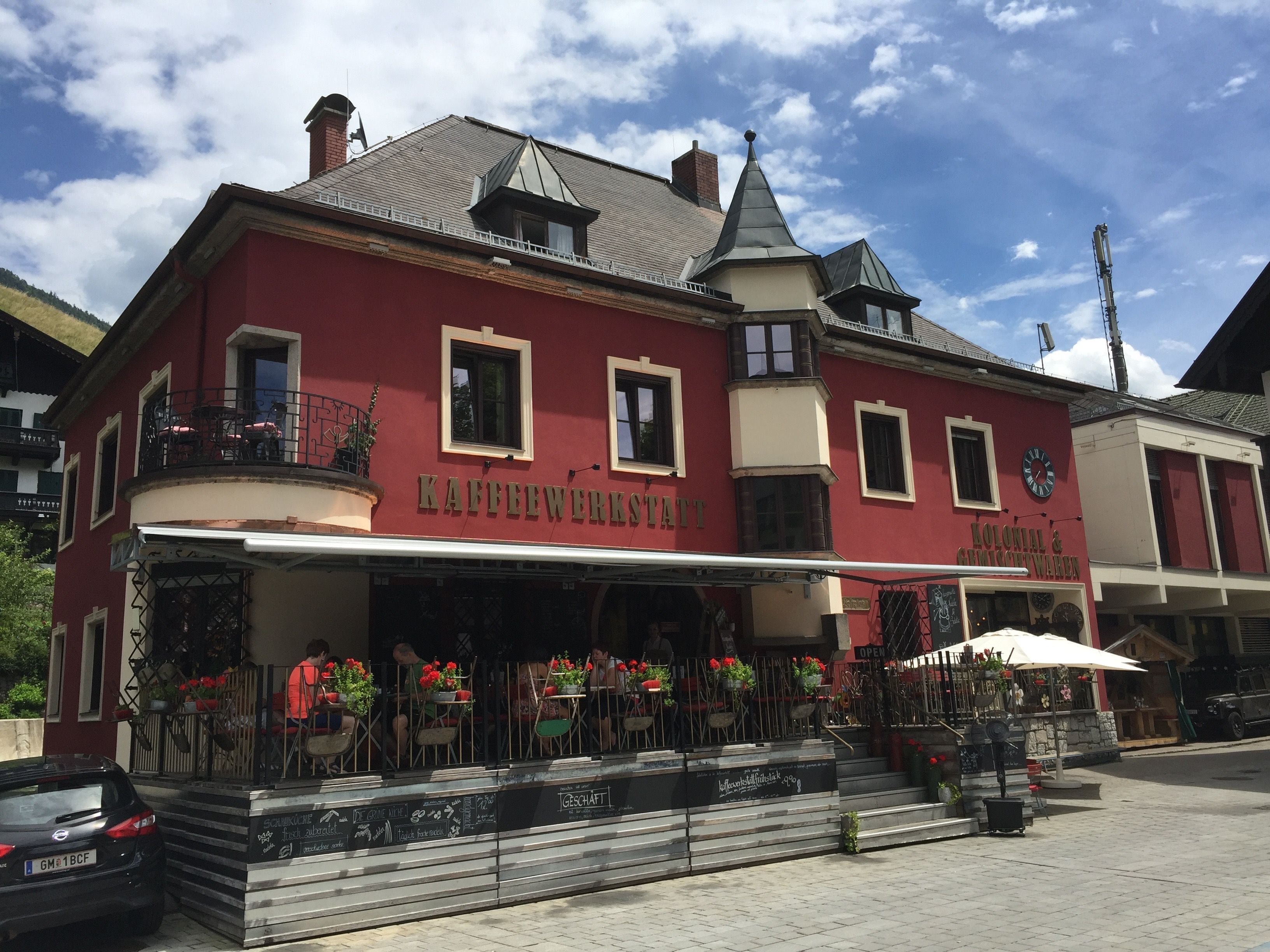 Ein rotes Gebäude mit einem Schild, auf dem 'Kaffeewerkstatt' und 'Colonial & Modernen' steht.