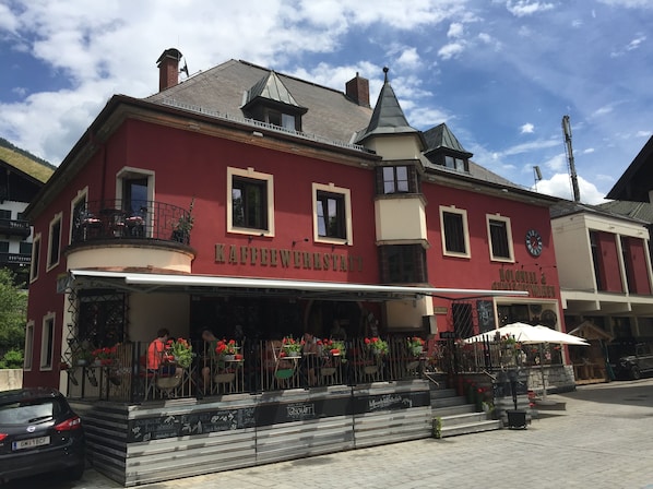 Un bâtiment rouge sur lequel on peut lire les inscriptions « Kaffeewerkstatt » et « Colonial & Modernen ».