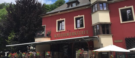 A building with a red facade and the name 'KAFFEEWERKSTATT' on the front.