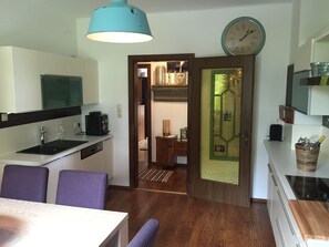Eine moderne Küche mit Spüle, Kaffeemaschine und Essbereich mit Stühlen.