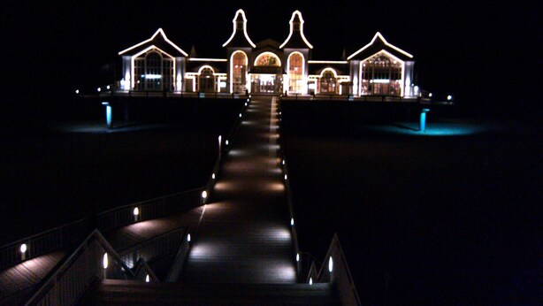 A hotel with a central building flanked by two wings, connected by a central walkway.