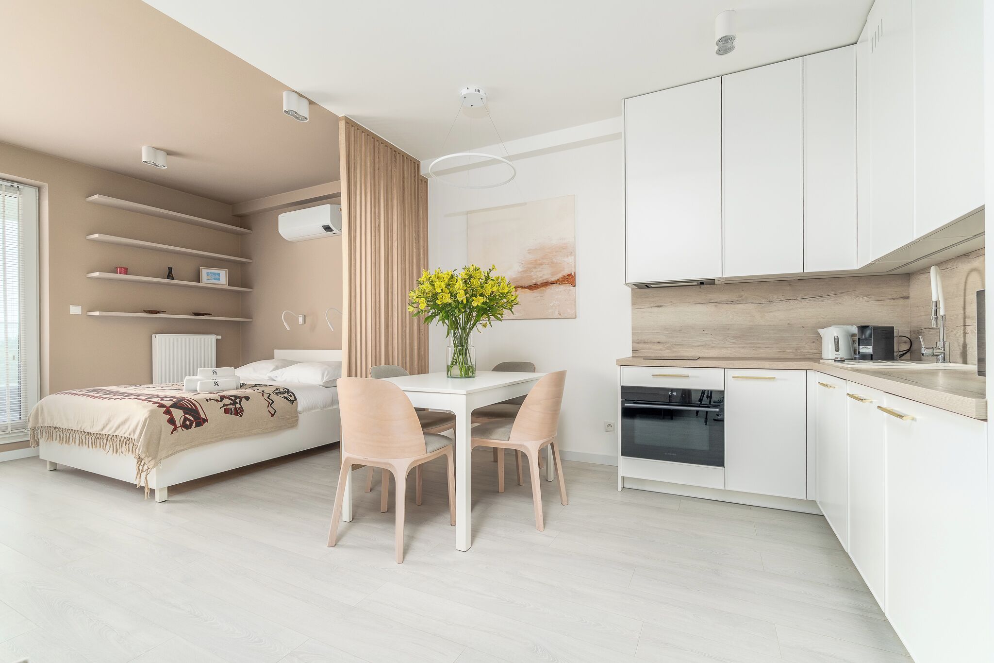 A modern bedroom with a bed, bedside table, and a bedside lamp.