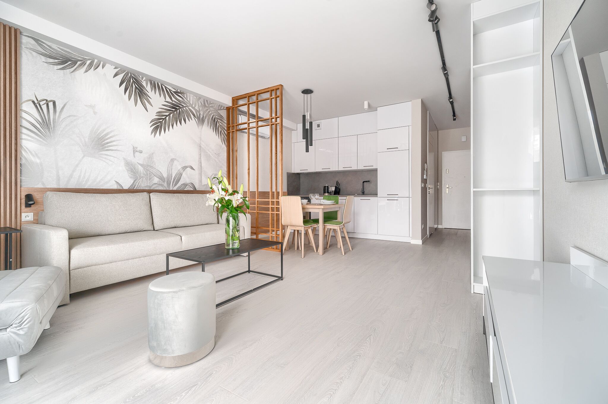 A modern living room with a sofa, coffee table, and dining area with chairs.