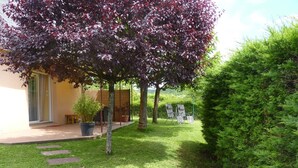 Un jardin bien entretenu, agrémenté d’une terrasse, de mobilier d’extérieur et d’une variété de plantes.
