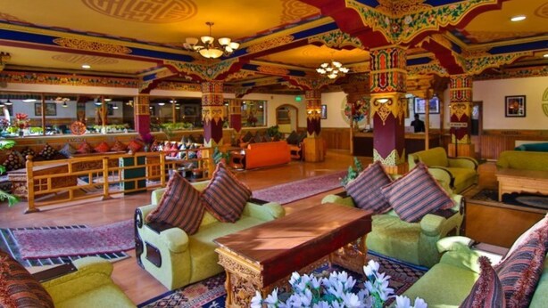 A traditional interior with ornate decor, seating arrangements, and a central table. - TIH Hotel Shangrila-Ladakh (Leh)