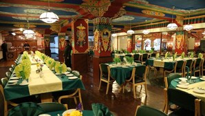 A banquet hall with long tables set for a formal event, featuring traditional decor and a polished wooden floor. - TIH Hotel Shangrila-Ladakh (Leh)