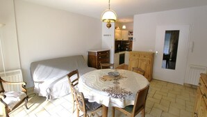 A compact living space with a dining area, kitchenette, and a bed. - Charming T2 in Barcelonnette with terrace for 4 people (Barcelonnette)