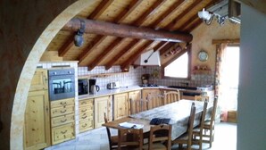 Eine rustikale Küche mit Holzschränken, einer großen Kochinsel und einer gewölbten Decke.