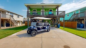 Un bâtiment à deux étages doté d’un balcon, d’une voiturette de golf et d’une cour clôturée.