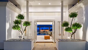 Ett modernt hus med en central hall som leder till ett vardagsrum med pool.