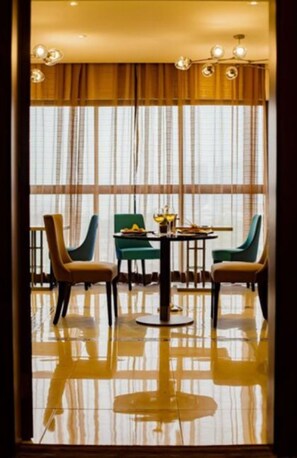 Un comedor con una mesa redonda, cuatro sillas y vistas amplias a través de grandes ventanales.